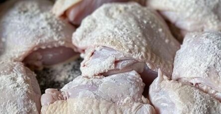 Coat chicken in flour and toss in slow cooker