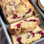 "Sliced cream cheese cranberry loaf on a wooden cutting board"