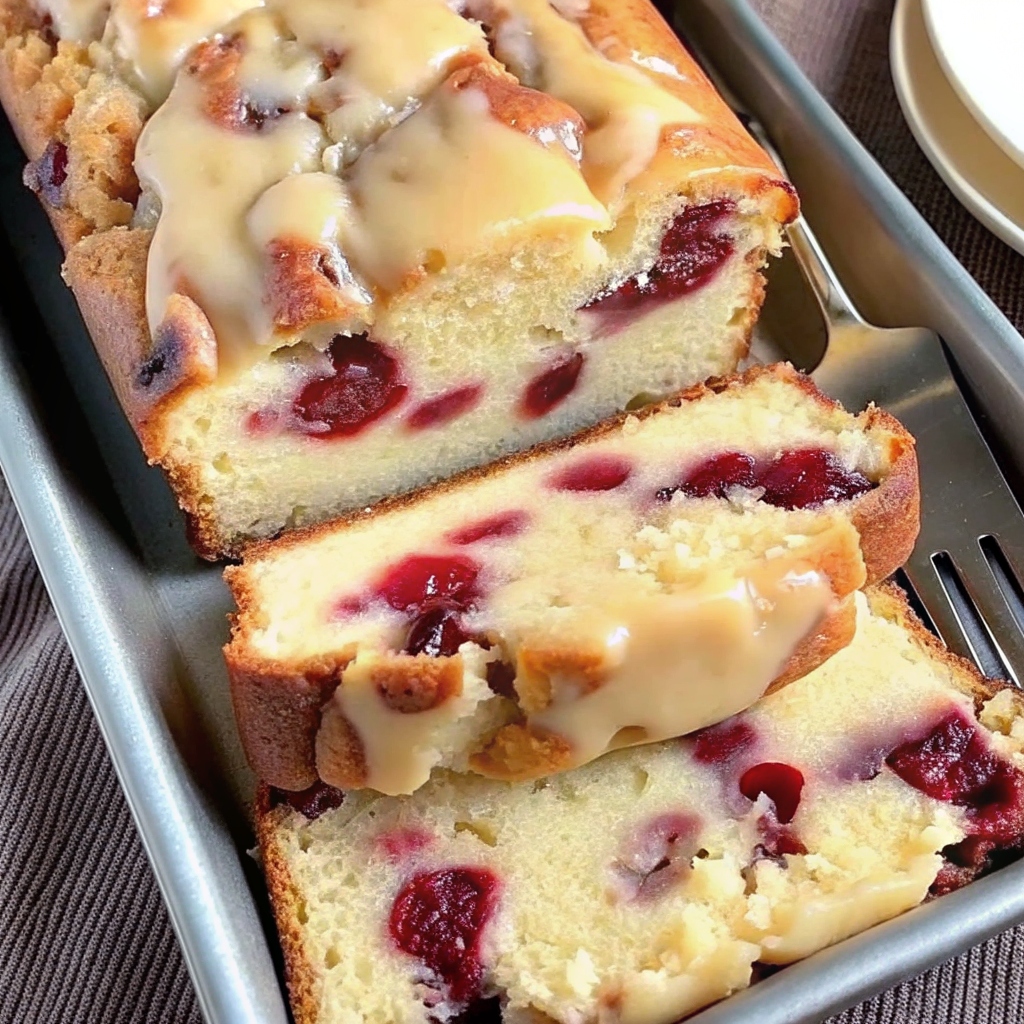 "Sliced cream cheese cranberry loaf on a wooden cutting board"