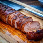 “Grilled pork tenderloin sliced and served with barbecue glaze”