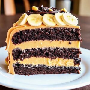 Double Chocolate Banana Layer Cake topped with creamy chocolate frosting and garnished with chocolate shavings and banana slices