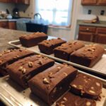 Homemade Toll House Famous Fudge cut into squares with chocolate morsels and nuts